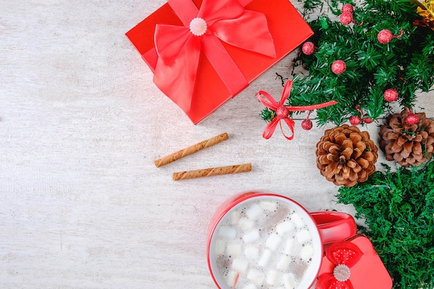 Taza de chocolate rojo cacao y caja de regalo roja con árbol de Navidad sobre fondo blanco