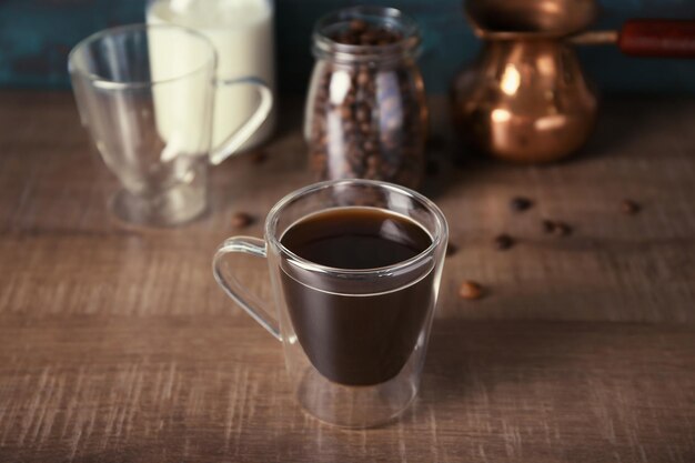 Taza de cristal con delicioso café en la mesa