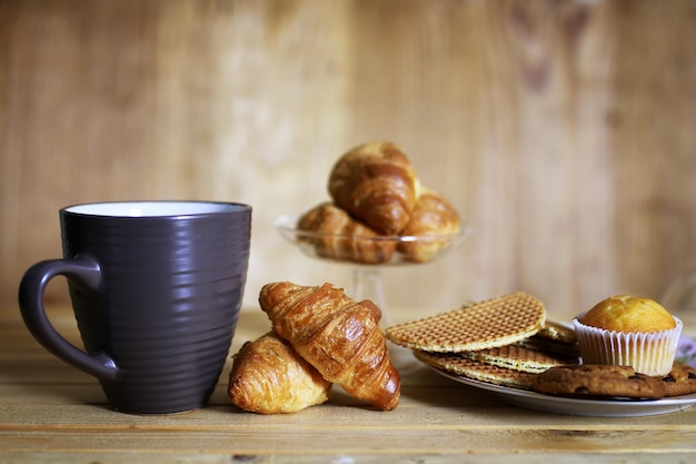 Taza croissant desayuno fondo madera