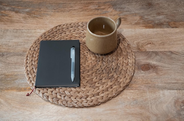 Taza de cuaderno y bolígrafo en la mesa