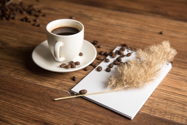 Taza de cuaderno de café y granos de café.