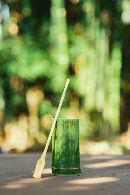 Foto taza y cuchara hechas a mano con madera de bambú. utensilio natural como recipiente para líquidos. reutilizar y reciclar tazas orgánicas.