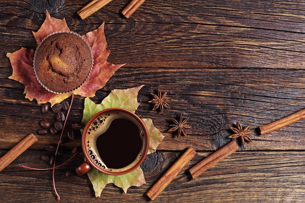 Taza de cupcake de chocolate y café caliente en la mesa de madera oscura, vista superior