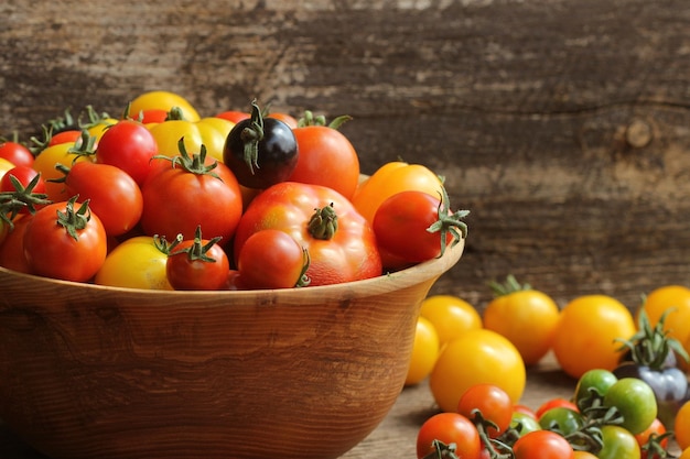 Taza de madeira com tomates frescos maduros do mercado de agricultores