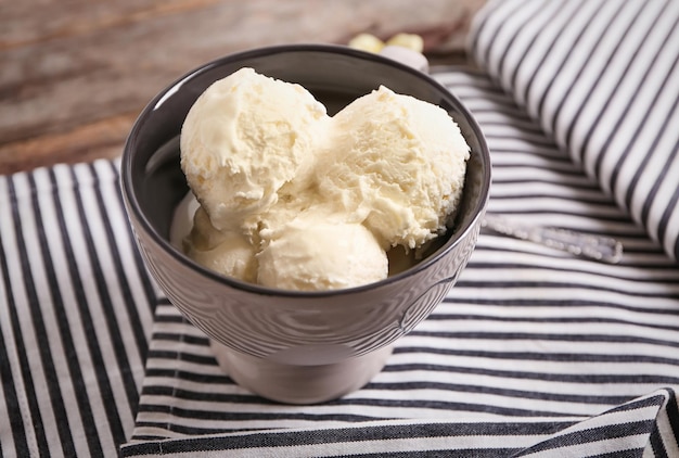 Taza con delicioso helado de vainilla en mesa