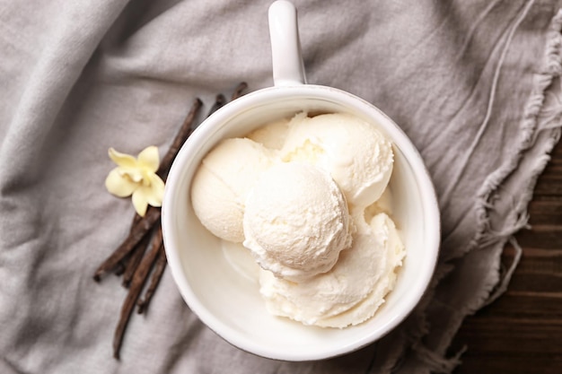 Foto taza con delicioso helado de vainilla en mesa