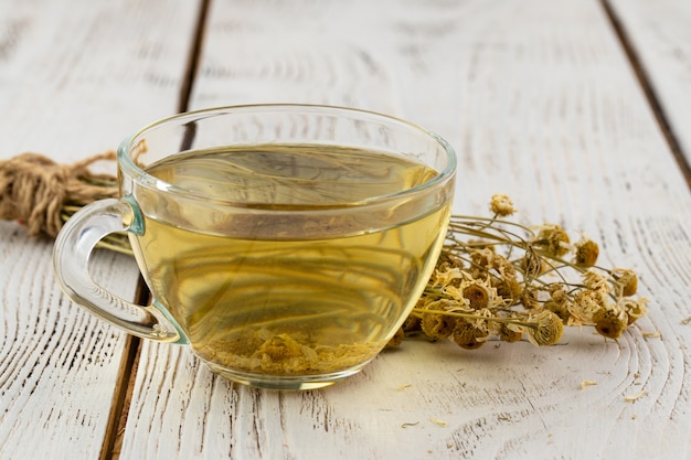 Taza de delicioso té de manzanilla en la mesa