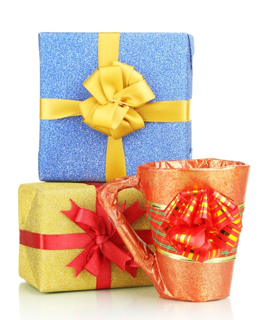 Taza embalada en papel de regalo con regalos aislado en blanco