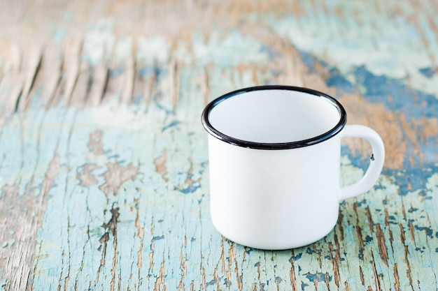 Taza esmaltada blanca vacía para acampar y viajar