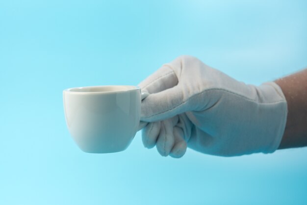 Foto taza de espresso en mano con guante