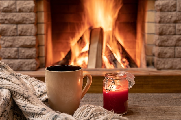 Taza grande con té caliente y una vela.