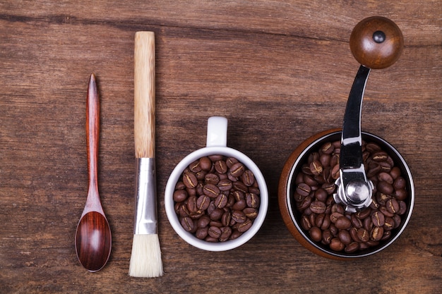 taza de granos de café y una cuchara en el fondo de madera marrón