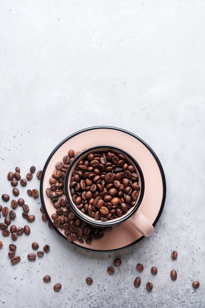 Taza con granos de café en el interior de hormigón gris