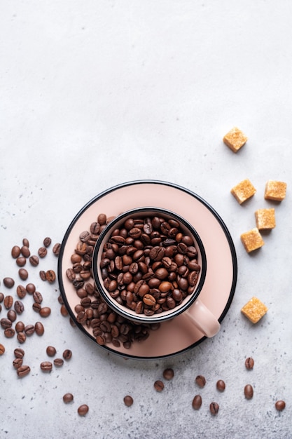 Taza con granos de café en el interior de hormigón gris