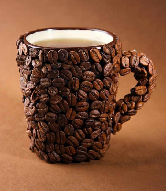 Taza de granos de café sobre fondo marrón