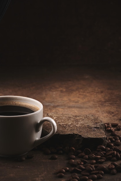 Taza de granos de café tostados recién hechos sobre fondo marrón