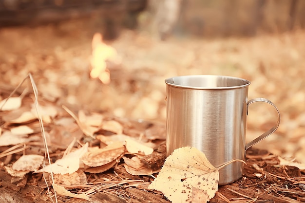 taza de hierro con té caliente en un viaje de campamento estilo de vida activo otoño parque amarillo