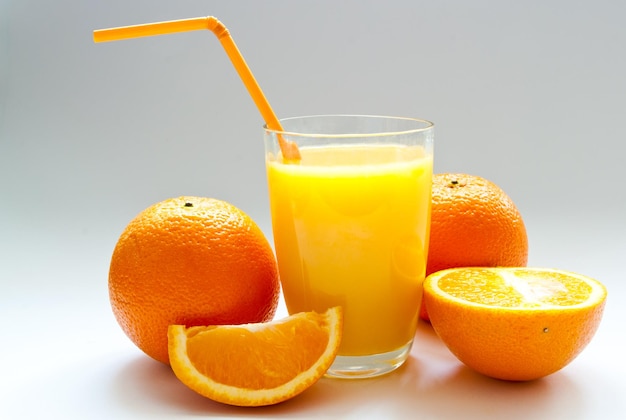 Una taza de jugo de naranja y naranja fresca.