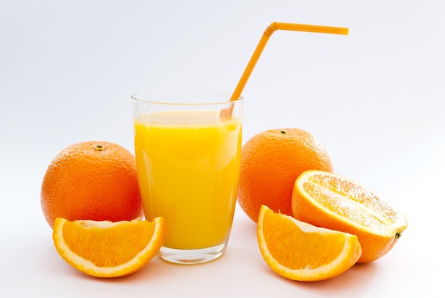 Una taza de jugo de naranja y naranja fresca.