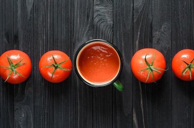 Foto taza de jugo de tomate en esmalte verde