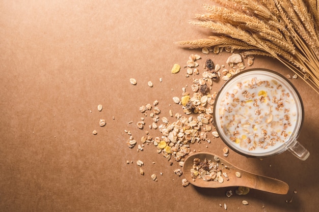 Una taza de leche con cereal en la mesa de madera. Concepto de desayuno saludable.