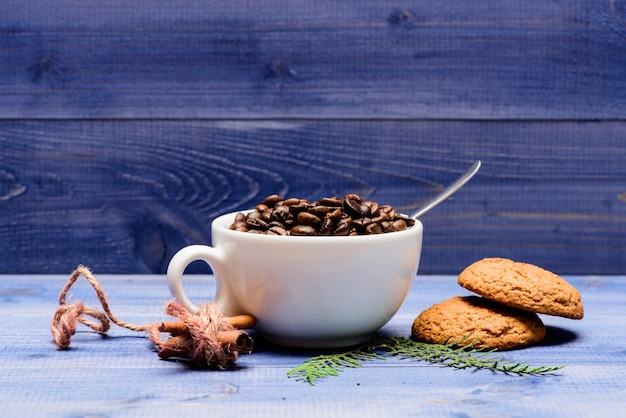 Taza llena de café café tostado frijol fondo azul de madera Concepto de cafeína Menú de bebidas de café Variedad de café Arábica robusta Bebida para inspiración y carga de energía Granos de café recién tostados