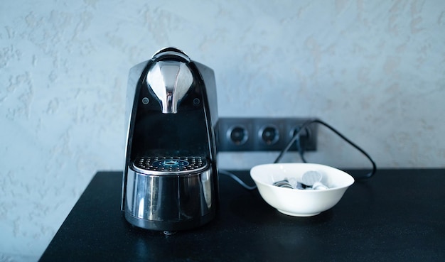 Taza de la máquina de café espresso profesional moderno en la mesa de la cocina desayunando por la mañana