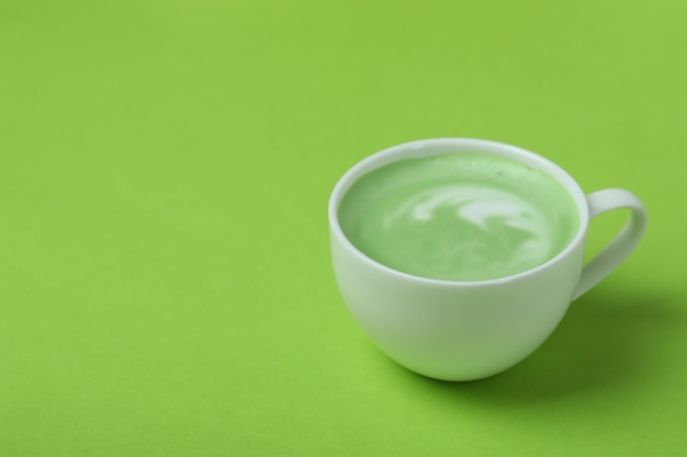 Taza de matcha latte sobre fondo verde