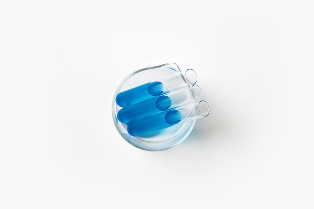 Taza con matraces para laboratorio con líquido azul cian Sobre un fondo de luz blanca Vista desde arriba