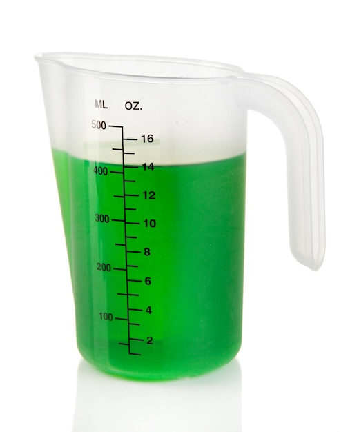 Taza medidora con líquido verde aislado en blanco