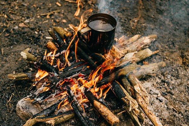 Taza de metal se calienta en la hoguera