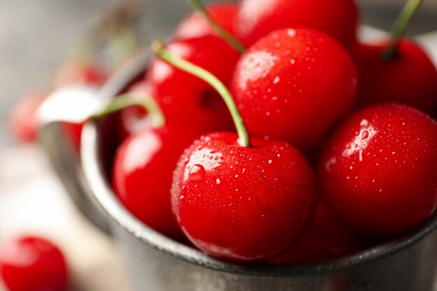 Taza de metal con cereza roja fresca, macro