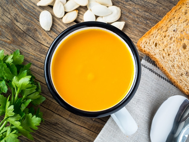 Taza de metal con sopa de calabaza.