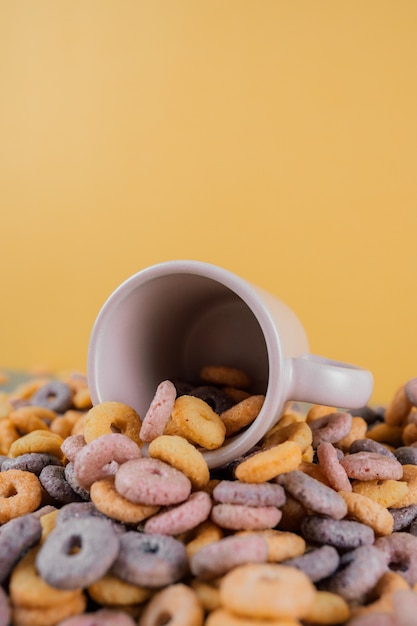 Taza y montón de cereales en la mesa