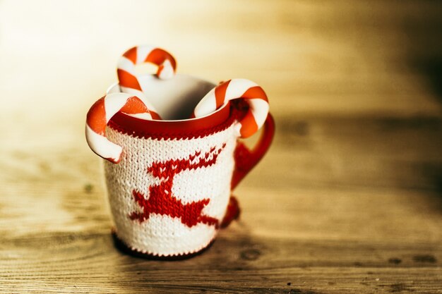 Taza de Navidad y velas sobre fondo de madera.Foto con espacio de copia