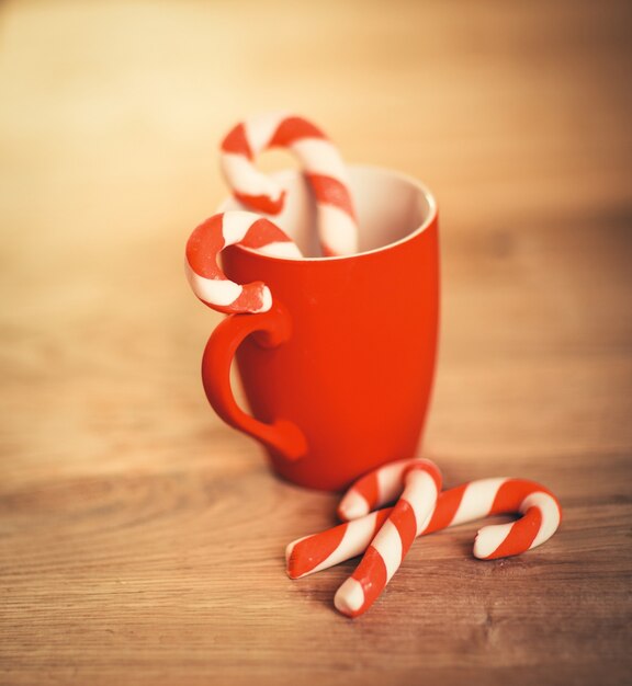 Taza de Navidad y velas sobre fondo de madera.Foto con espacio de copia