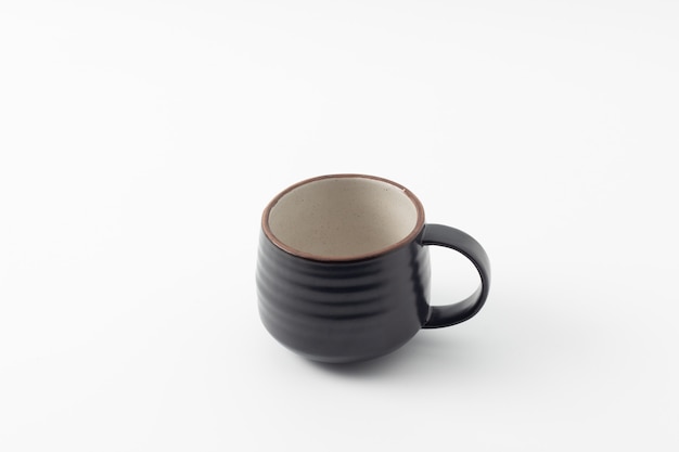 Taza negra sobre un fondo blanco aislado