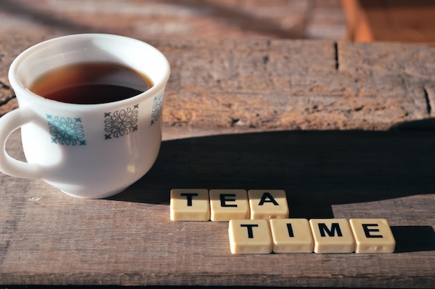 Una taza de nescafé y letras cuadradas con texto TEA TIM