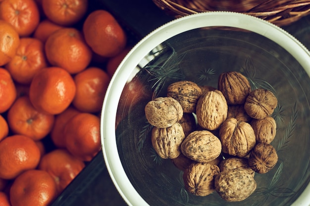 Taza de nueces y clementinas frescas sobre fondo en cocina vegana