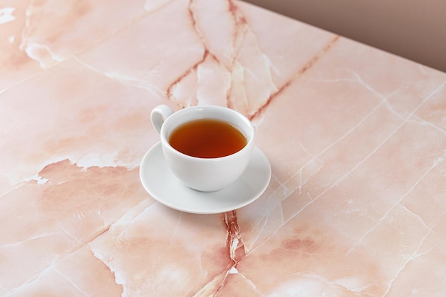 Taza o taza de té negro sobre fondo de mármol rosa beige Concepto minimalista ecológico Espacio de copia