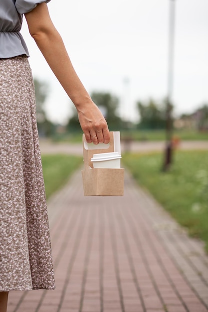 Taza de papel blanco con café en la mano de la mujer Hora de tomar café