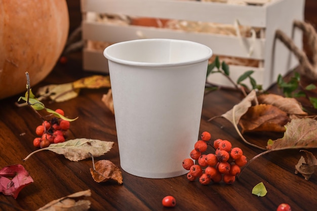 Taza de papel blanco en el paisaje de otoño