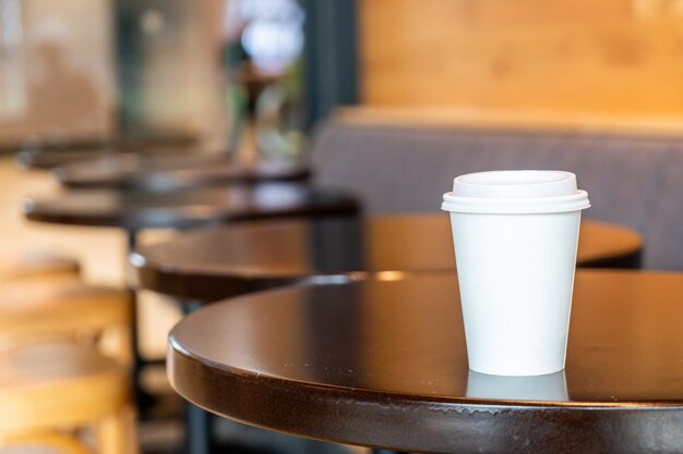 Foto taza de papel de café caliente en la cafetería