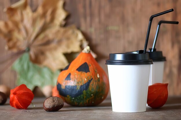 Taza de papel de café sobre la mesa con calabaza