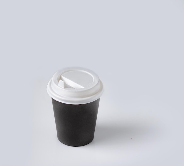 taza de papel negro para el café en el espacio de vidrio blanco copia de maqueta aislar