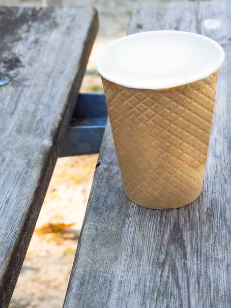 Foto taza de papel pequeña maqueta sobre fondo de madera clara