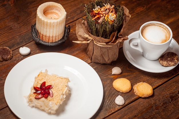 Taza de pastel dulce de café en la mesa festiva de madera