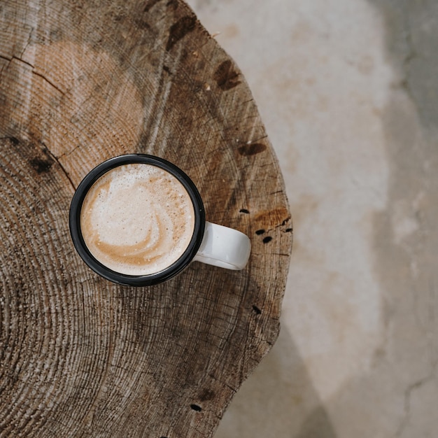 Taza plana con café con leche en una mesa de tronco de madera Estética plana vista superior concepto de estilo de vida de la vida muerta