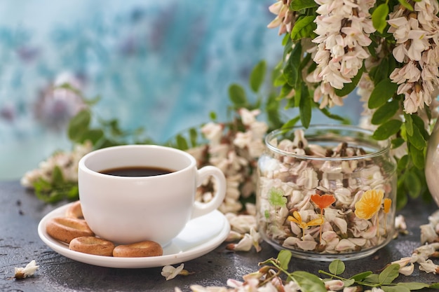 Taza de primer plano de café y acacia. Nutrición. fondo con una taza de café y flores de acacia.