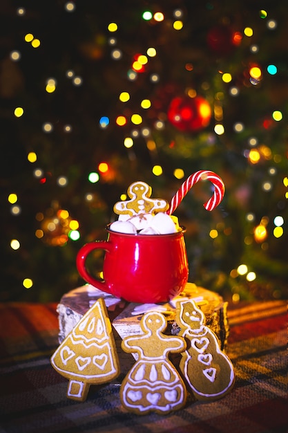 Taza roja con cacao y malvaviscos. Pan de jengibre casero. Adornos navideños tradicionales.